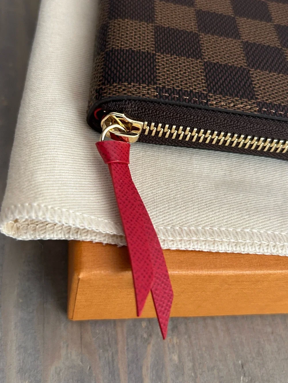 Authentic Louis Vuitton Damier Ebene Zip-Around Wallet with Red Leather Pull